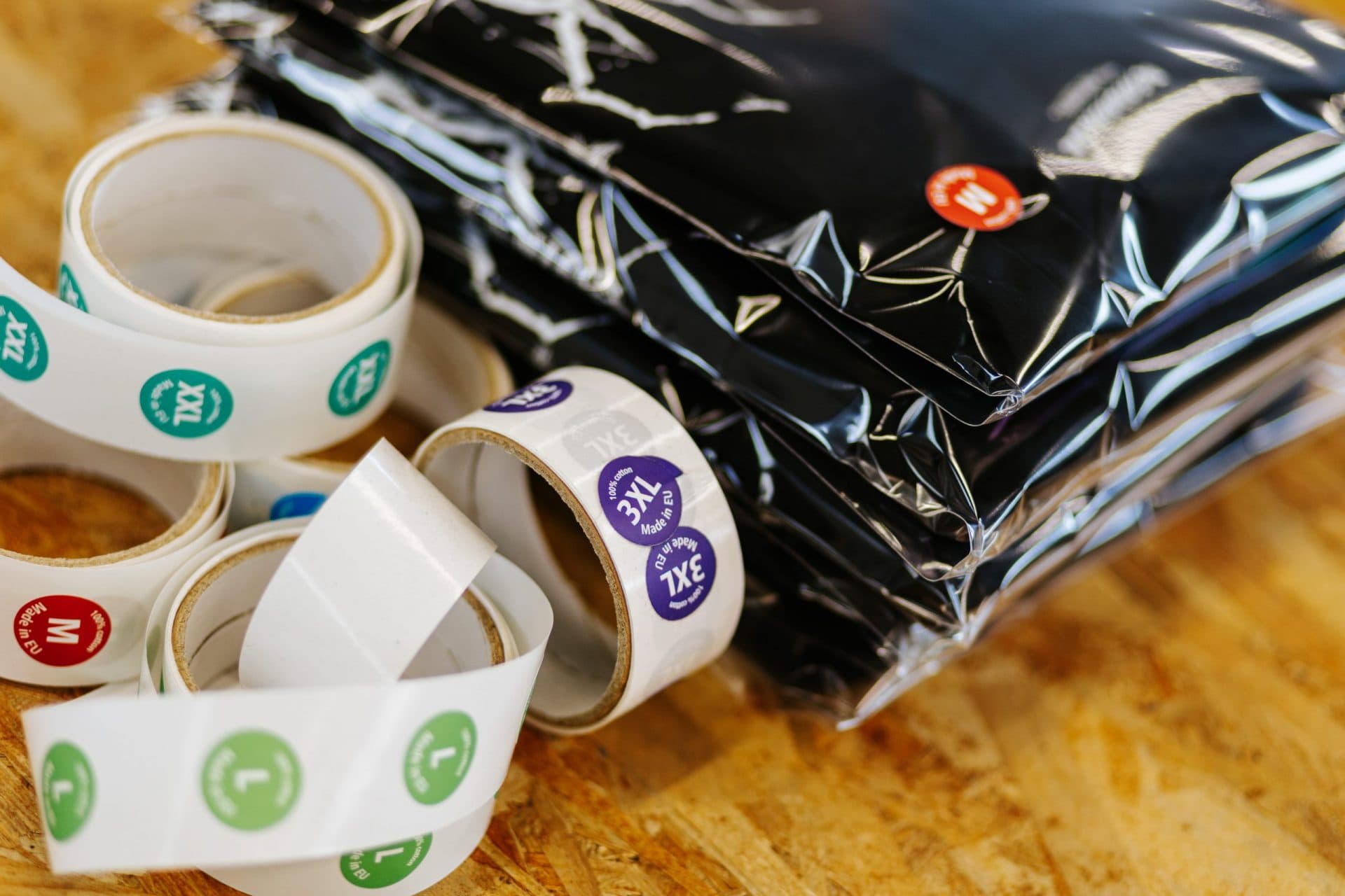 Custom branded packaging materials including colored tape rolls and poly mailers for merchandise