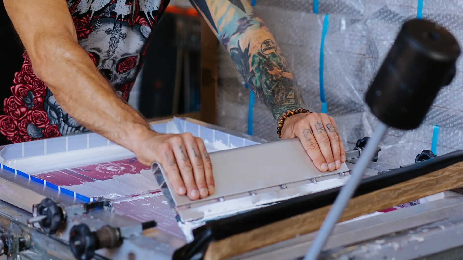 Screen printing operators preparing custom transfer designs for band merchandise production